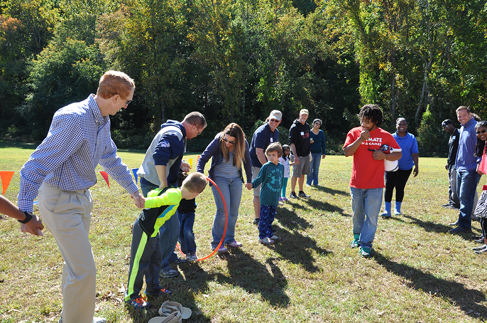 Double line up with parents and children for a group game at company picnic