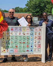 Gunnison Employees and CEO at Cedar Grove Elementary School celebrating Gunnison's expanded philanthropic partnership standing around a healthy activity sign in the playground.